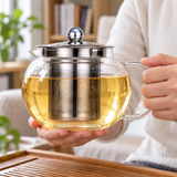 JN63G-2 glass infuser teapot in a two-handed carrying setting; contextual accessories not included.