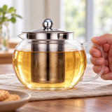 JN63G-2 glass infuser teapot in a table handle-grip setting; contextual accessories not included.