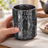 KA70-5 dark mottled ceramic teacup in a hand-held tea setting; contextual accessories not included.