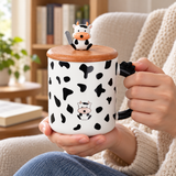 PC33-1 cow-pattern lidded mug in a two-handed carrying setting; contextual accessories not included.