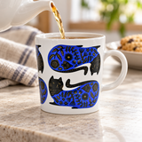 Blue-and-black cat mug in a pouring setting. Contextual accessories are not included.