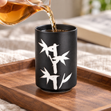 TCC23 black-and-white teacup in a tea pouring setting; contextual accessories not included.