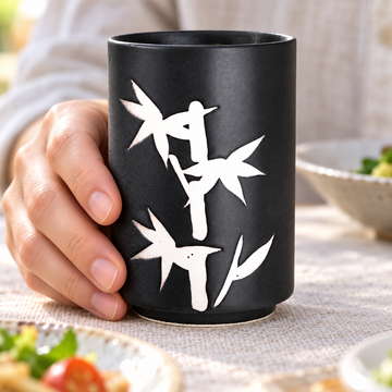 TCC23 black-and-white teacup in a hand-held lunch setting; contextual accessories not included.