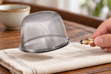 6592-85 stainless-steel tea strainer held inverted by its short bamboo grip; contextual accessories not included.