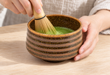 Preparing matcha in the K537-BR brown-banded bowl with a contextual bamboo whisk, not included.