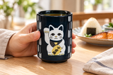 MN70-BLC black lucky-cat teacup held at breakfast; food and tabletop accessories are contextual.