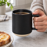 Black ceramic C001BK mug with angular handle held beside breakfast toast