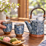 Blue-gray floral teapot and two matching cups during shared tea service