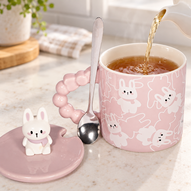 Rabbit-pattern mug being filled with tea, matching lid and spoon beside it