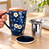 SM13-6719 cobalt sakura mug held with tea beside its lid and infuser