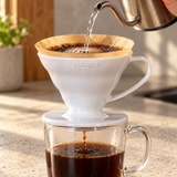 White HARIO V60 01 dripper brewing coffee into a glass cup