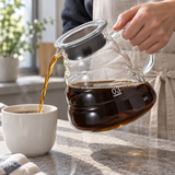 HARIO size 03 clear glass coffee server pouring coffee into a cup; cups and other props not included.
