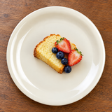 Ivory narrow-rim dinner plate with small cake and berries