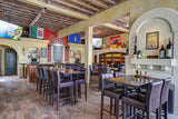 Dark Brown Upholstered Restaurant Barstool with Wood-Grain Metal Frame in a restaurant setting; other furniture is illustrative