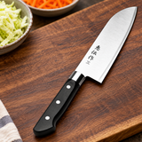DTNE-01 stainless steel cooking knife on a dark preparation board