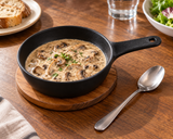 6″ Textured Black Ceramic Serving Pan with Handle — 18 oz with a mushroom sauce portion; table accessories shown separately