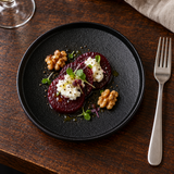 6¼″ Textured Black Porcelain Stackable Round Plate with a composed starter; table accessories shown separately