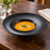 10¾″ Textured Black Ceramic Wide-Rim Bowl — 10 oz with a small soup serving; table accessories shown separately