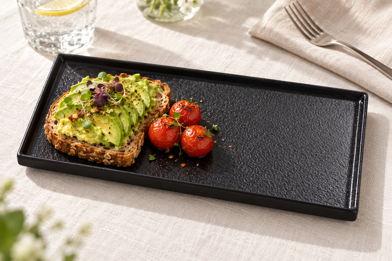 11¾″ × 6½″ Textured Black Ceramic Stackable Rectangular Plate with avocado toast and tomatoes; table accessories shown separately