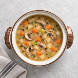 Brown-rimmed ceramic casserole with mushroom and vegetable soup