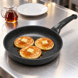 10" Durastone Marble Cast Aluminum Fry Pan with a finished meal on a restaurant counter