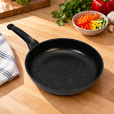 12.5" Durastone Marble Cast Aluminum Fry Pan on a restaurant preparation counter