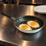 8-inch aluminum frying pan with two eggs at a restaurant pass