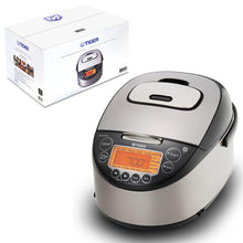 Tiger JKT-D series silver and black induction rice cooker beside a Tiger carton, with orange LCD and English menu controls.