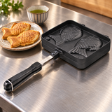Two-mold aluminum taiyaki maker beside fish-shaped cakes ready for service