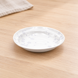 One larger pale sakura plate from the 15057 ten-piece set in a tabletop setting