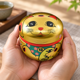 18SC1G gold-tone lucky cat tea container cradled in hands
