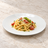 White round dinner plate with tomato pasta