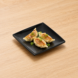 29007BK black melamine plate with three small dumplings. Serving suggestion.