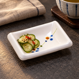 310-HM005 Rain Flower sauce dish with cucumber pickles on a dark tabletop