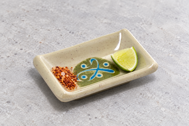 310-M rectangular sauce dish with a green-rind citrus wedge and a separate pile of red seasoning flakes.
