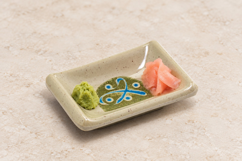 310-M rectangular dish with a green condiment at one end and pink pickled slices at the other, leaving the central motif visible.
