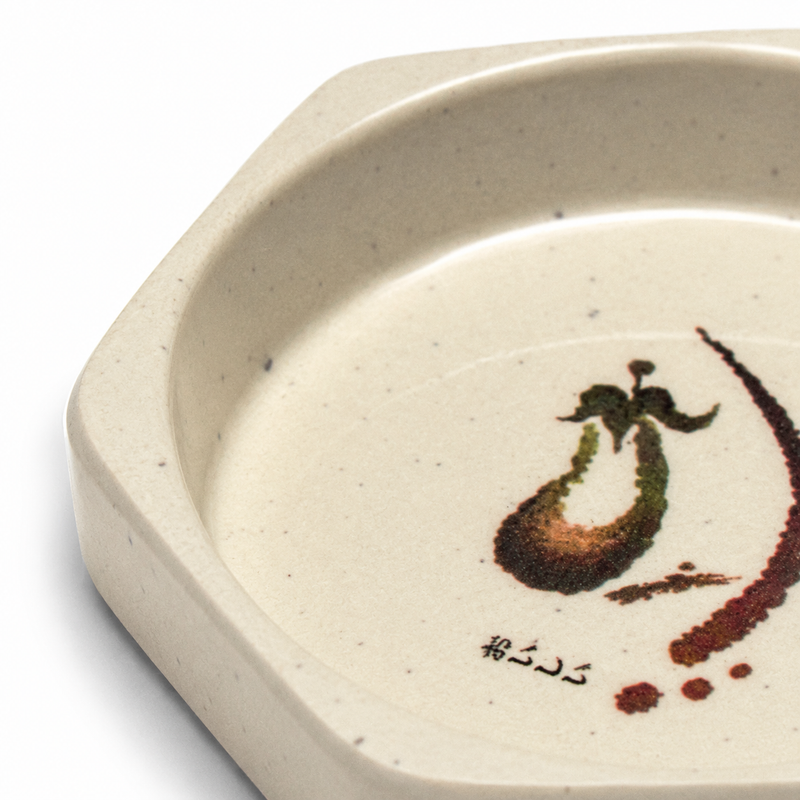 Close-up of the octagonal rim and central eggplant illustration.