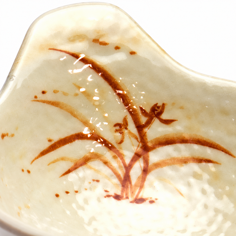 Close-up of the orchid motif and dimpled interior beneath the bowl's extended lip.