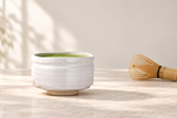 4313-H01: Matcha on pale stone with a bamboo whisk.