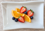 YG-507SW ivory melamine rectangular plate with citrus, strawberries and blueberries.