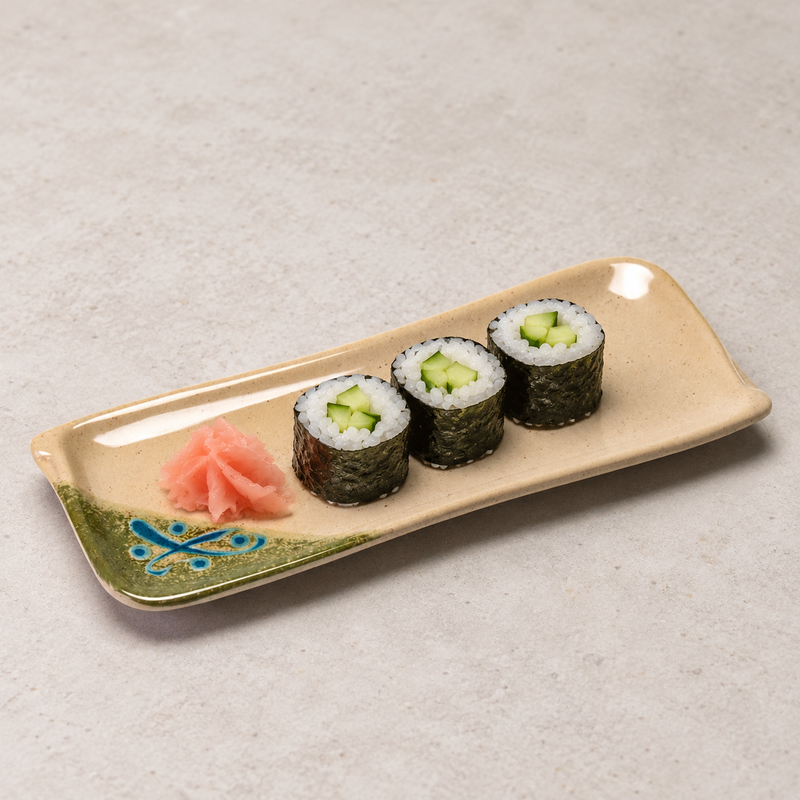 Three cucumber sushi rolls and pink pickled ginger arranged on the 510-M long rectangular patterned plate.