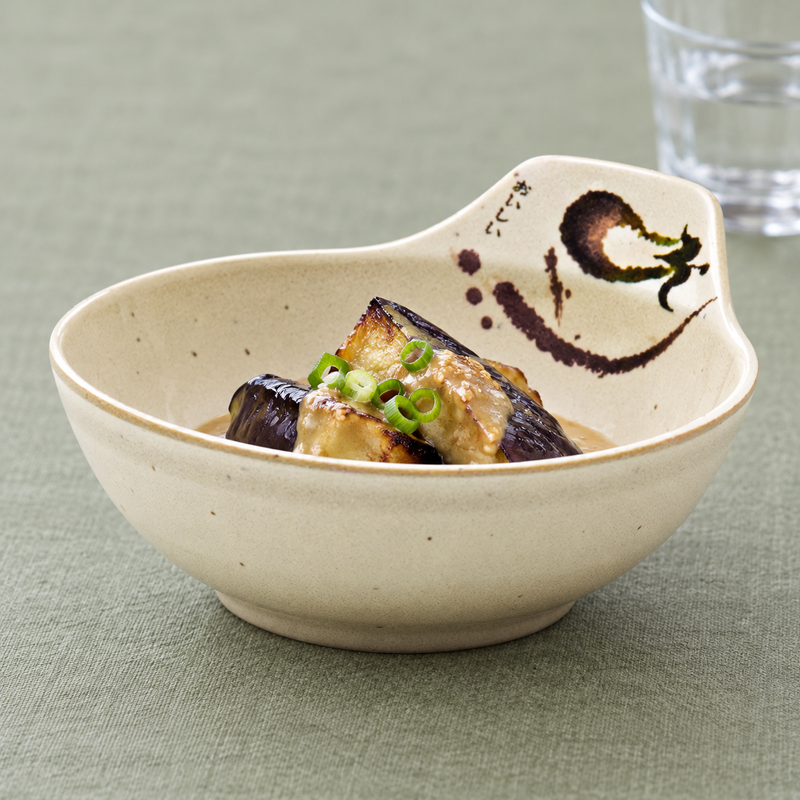 Raised-back melamine bowl holding dressed eggplant pieces and scallions.