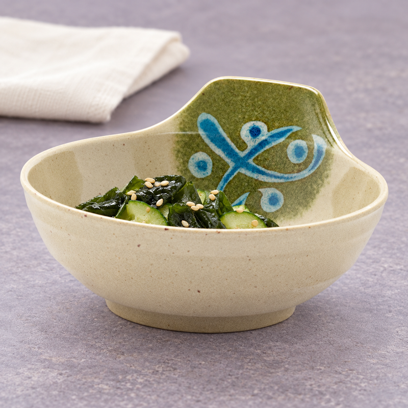 Cucumber slices, dark seaweed and sesame in the 5100-M patterned bowl, with a folded light napkin behind it.