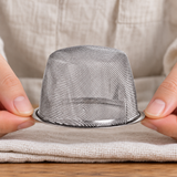 5490-75 inverted fine mesh tea basket held carefully at the rim