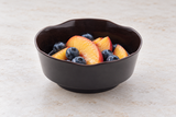 Dark scalloped bowl with peaches and blueberries