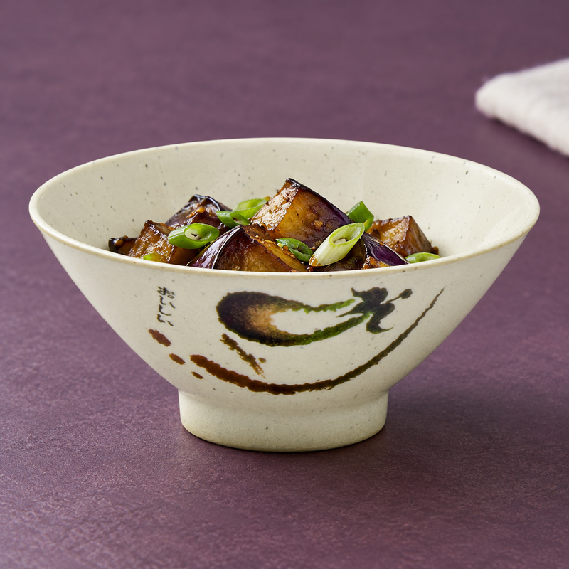 Speckled beige Eggplant bowl filled with eggplant pieces and scallions.