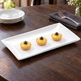 A1655 white rectangular ceramic plate presenting three small lemon tartlets at a dessert table