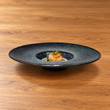 9.25" Obsidian Ceramic Wide-Rim Deep Plate with a restaurant serving