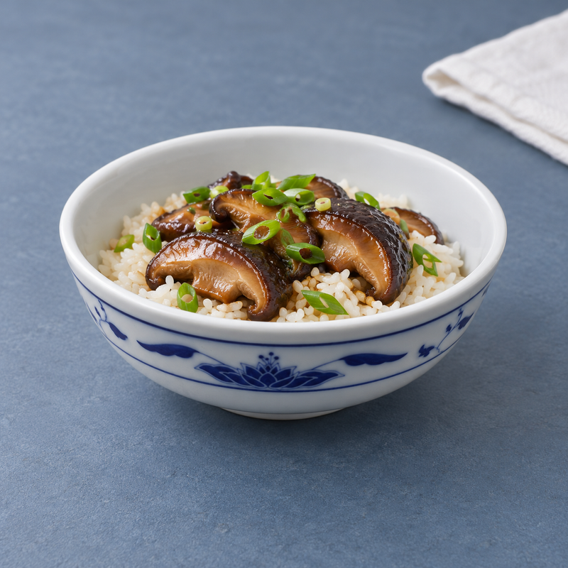 Blue Lotus porcelain bowl holding rice topped with mushrooms and scallions.