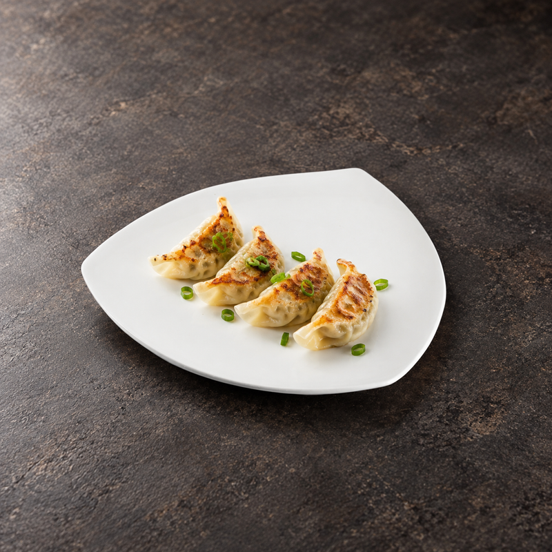 A7611 white ceramic triangular plate with four gyoza on a restaurant tabletop; food not included.
